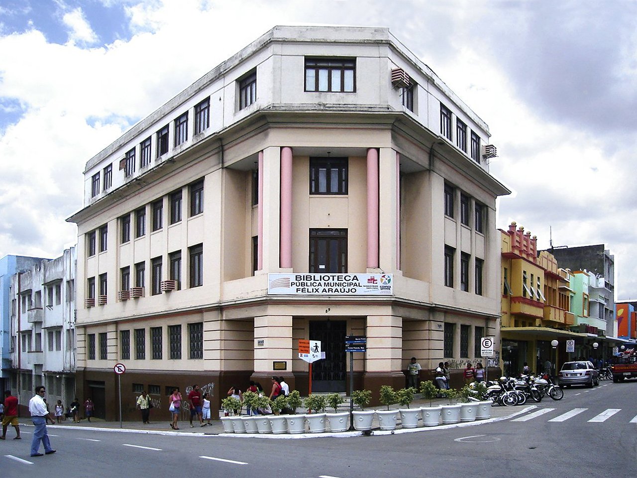 Biblioteca Pública Municipal Félix Araújo, prédio Art Déco de esquina em Campina Grande, com fachada chanfrada e colunas cilíndricas, em rua movimentada do centro.