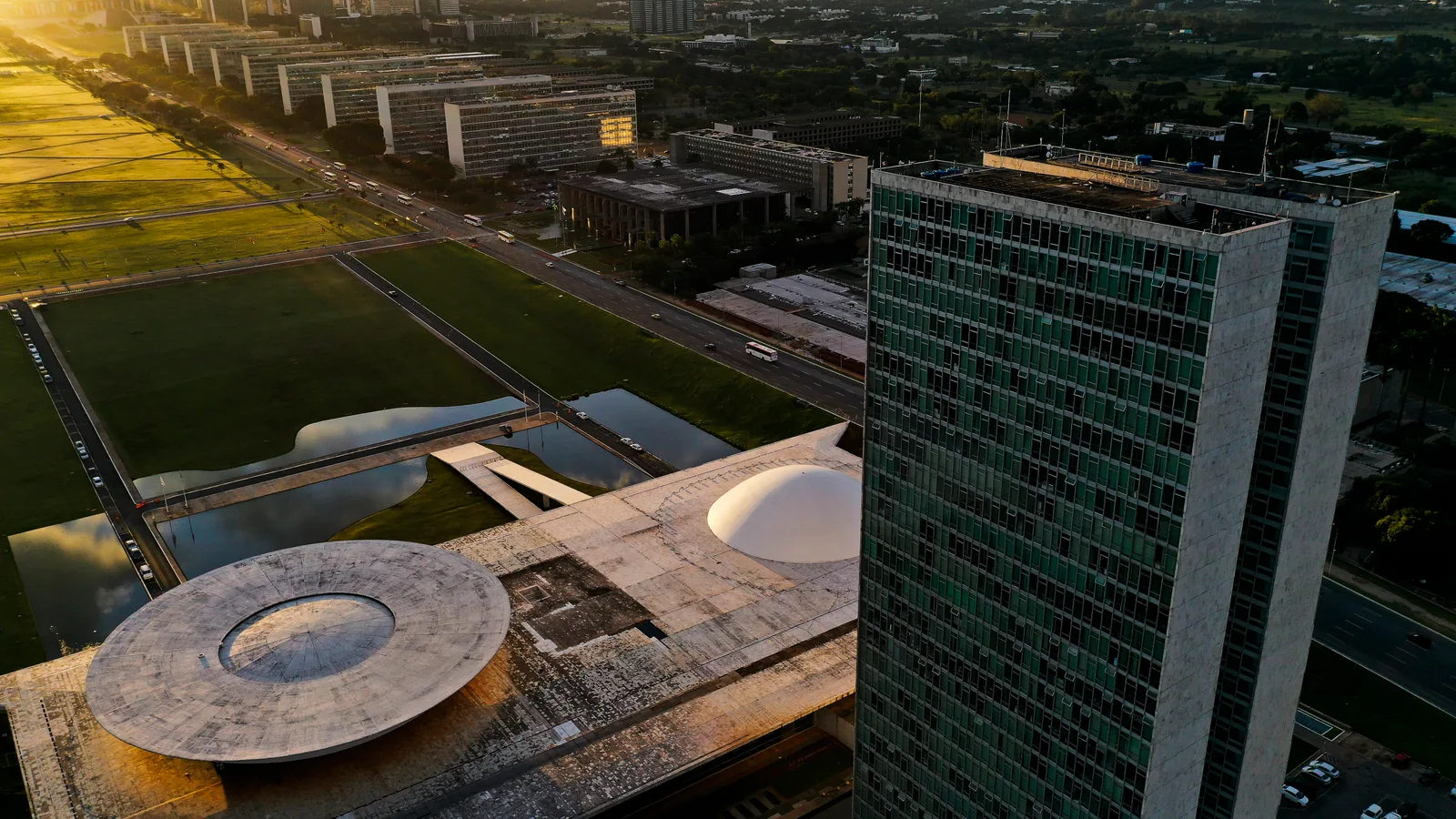 Vista aérea da Esplanada dos Ministérios e do Congresso Nacional, em Brasília, ao entardecer.