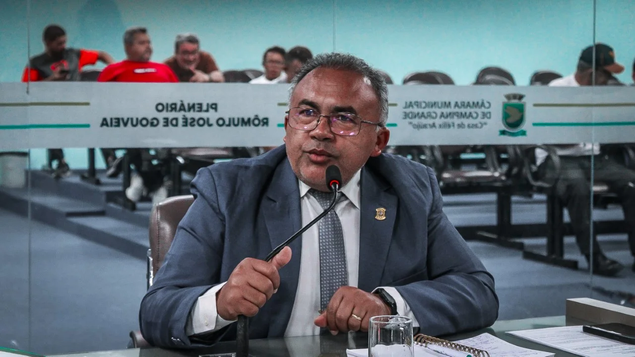 Vereador fala ao microfone na tribuna do plenário Rômulo José de Gouveia, com a identificação da Câmara Municipal de Campina Grande ao fundo.