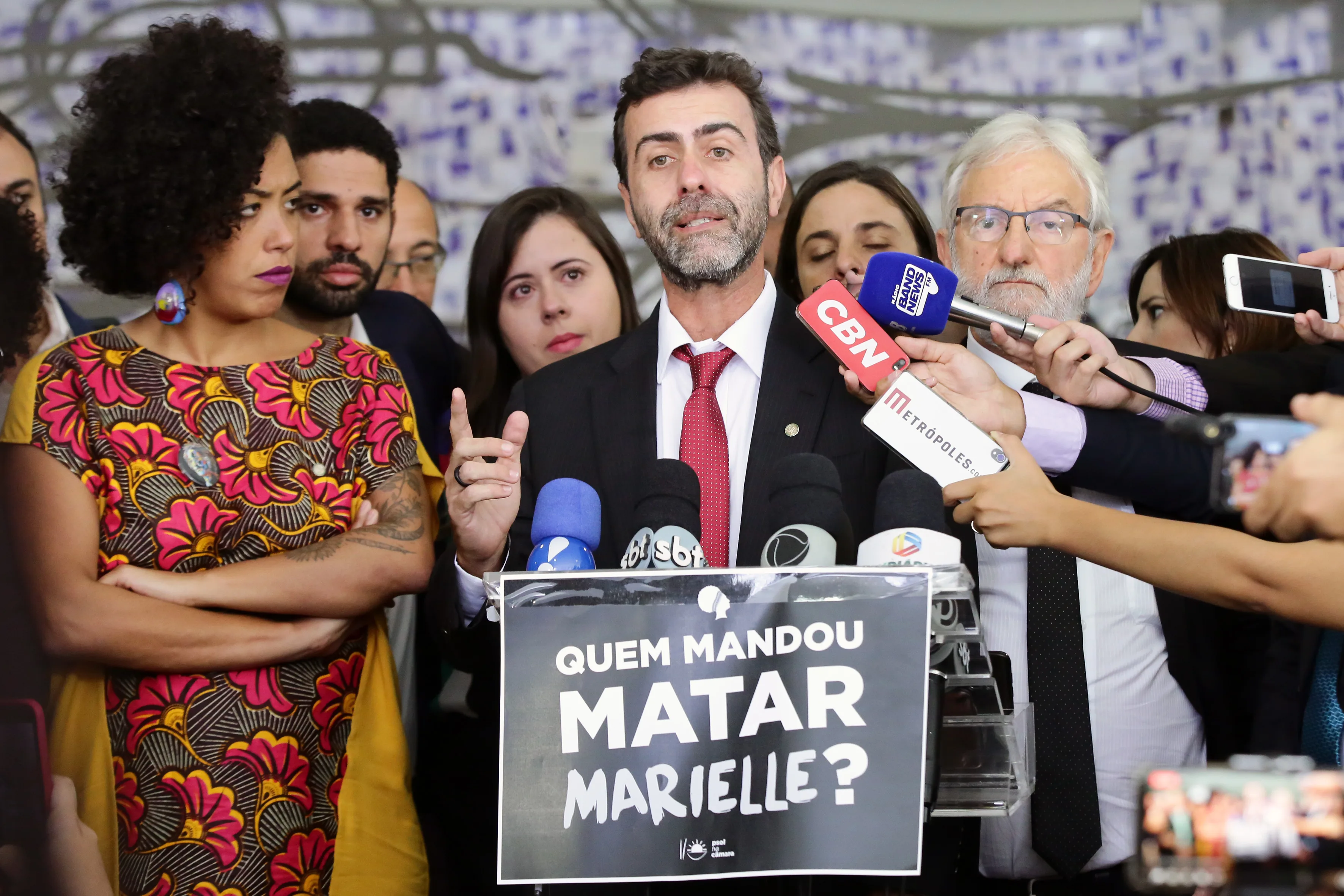 Parlamentares em coletiva de imprensa atrás de um cartaz com a pergunta Quem mandou matar Marielle.