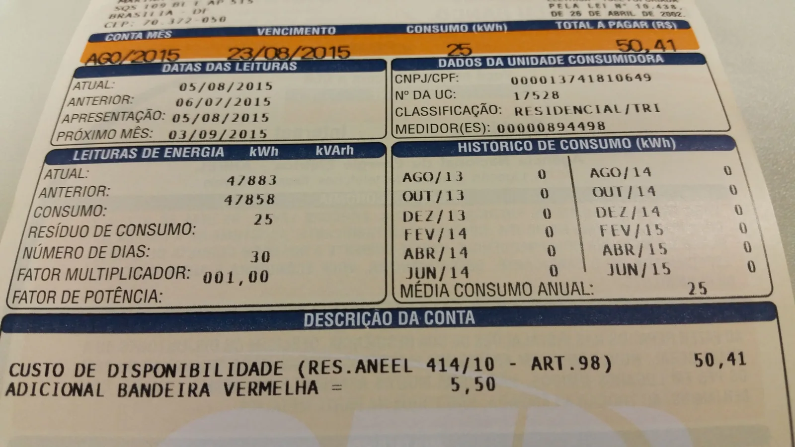 Detalhe de uma conta de energia elétrica impressa, com campos de consumo em kWh e histórico mensal.