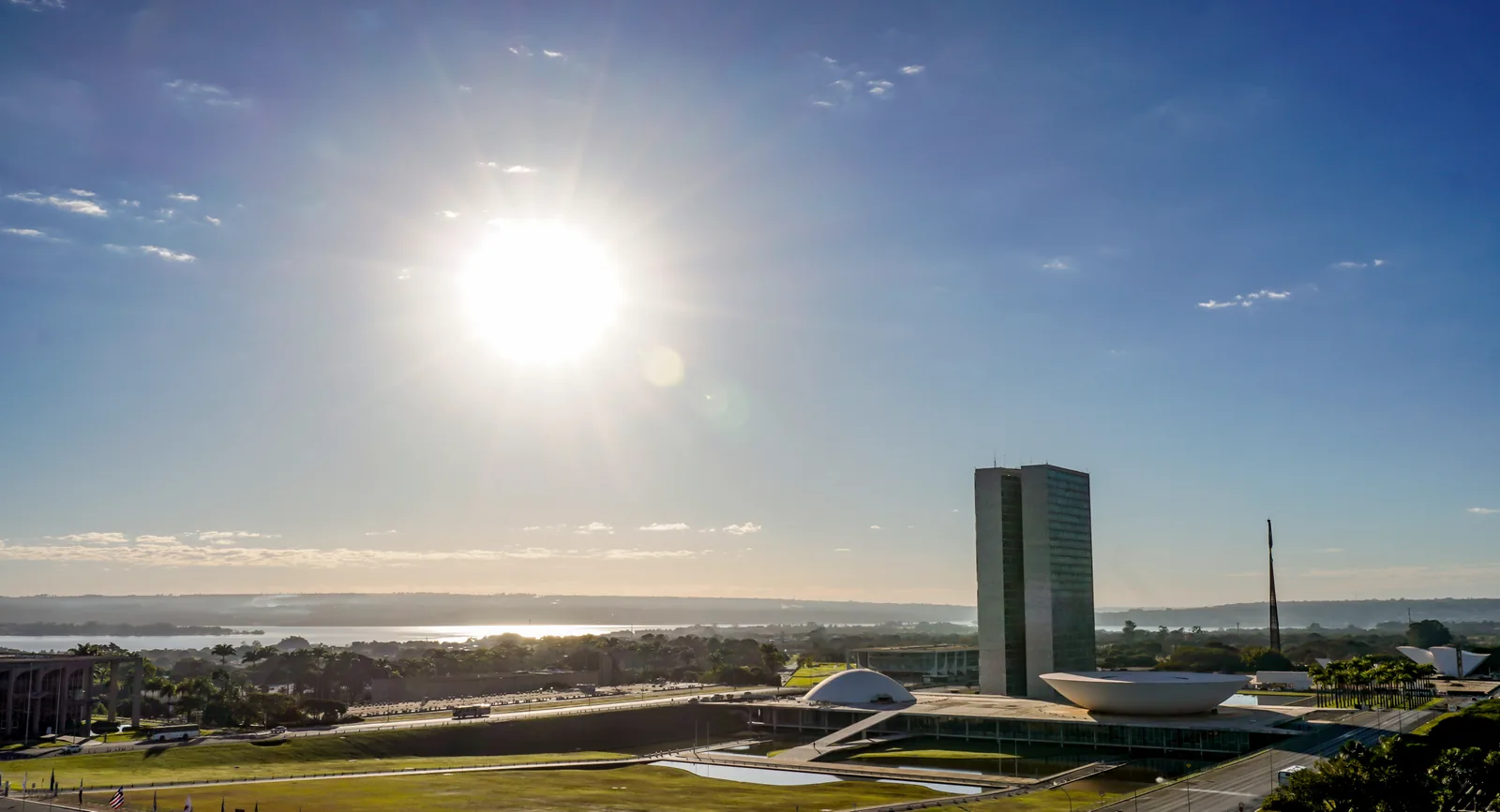 O sol nasce sobre a Esplanada dos Ministérios, em Brasília, com as torres e as cúpulas do Congresso Nacional ao fundo.