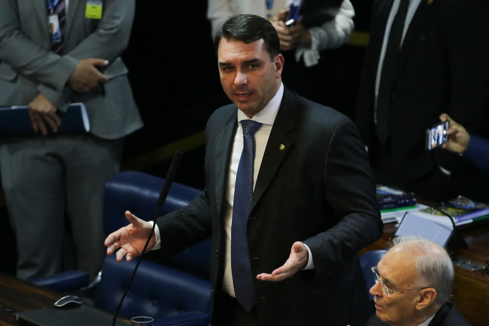 Flávio Bolsonaro, de terno escuro, gesticula ao falar no plenário do Senado.