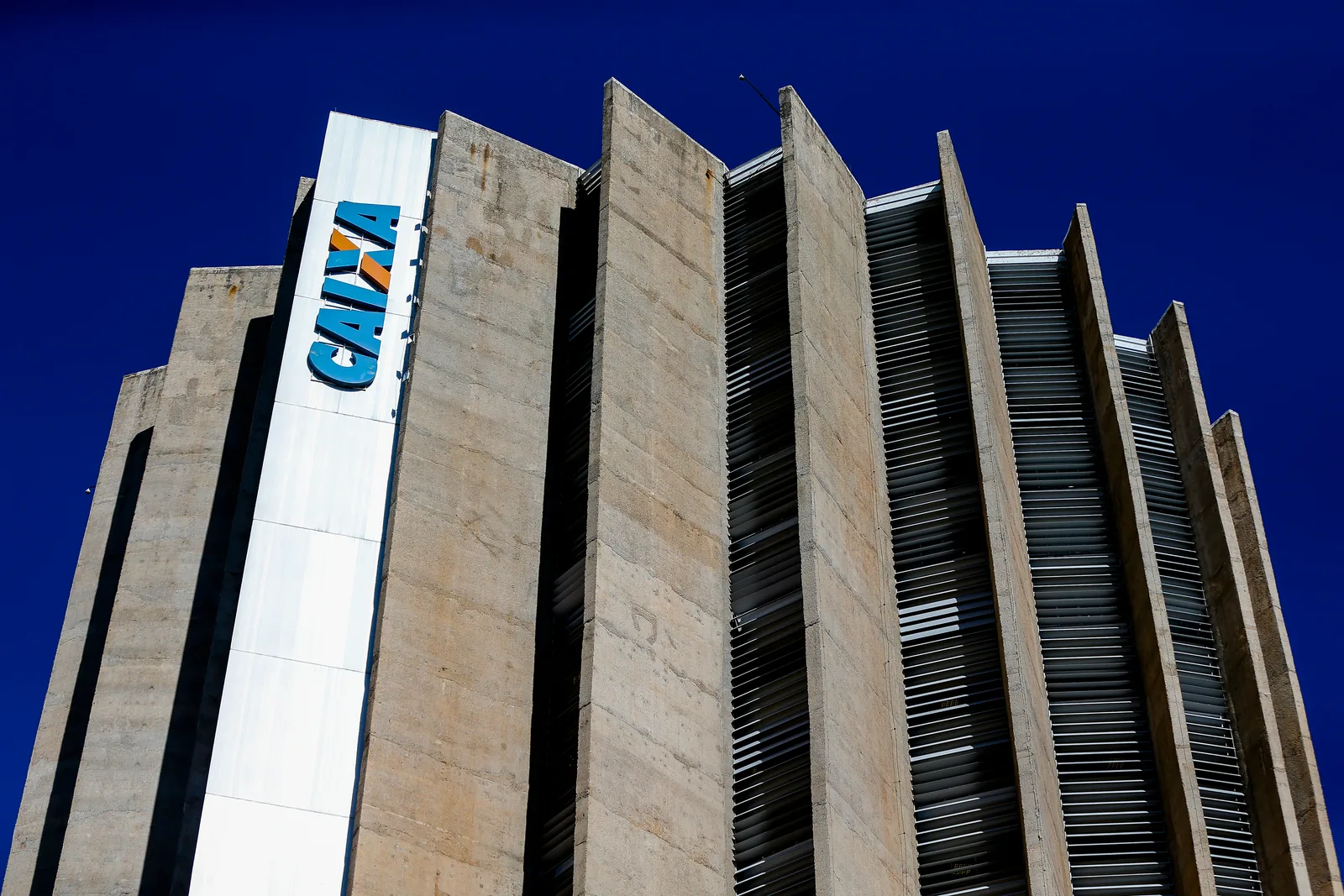 Fachada do edifício-sede da Caixa Econômica Federal, com o logotipo CAIXA, vista de baixo.