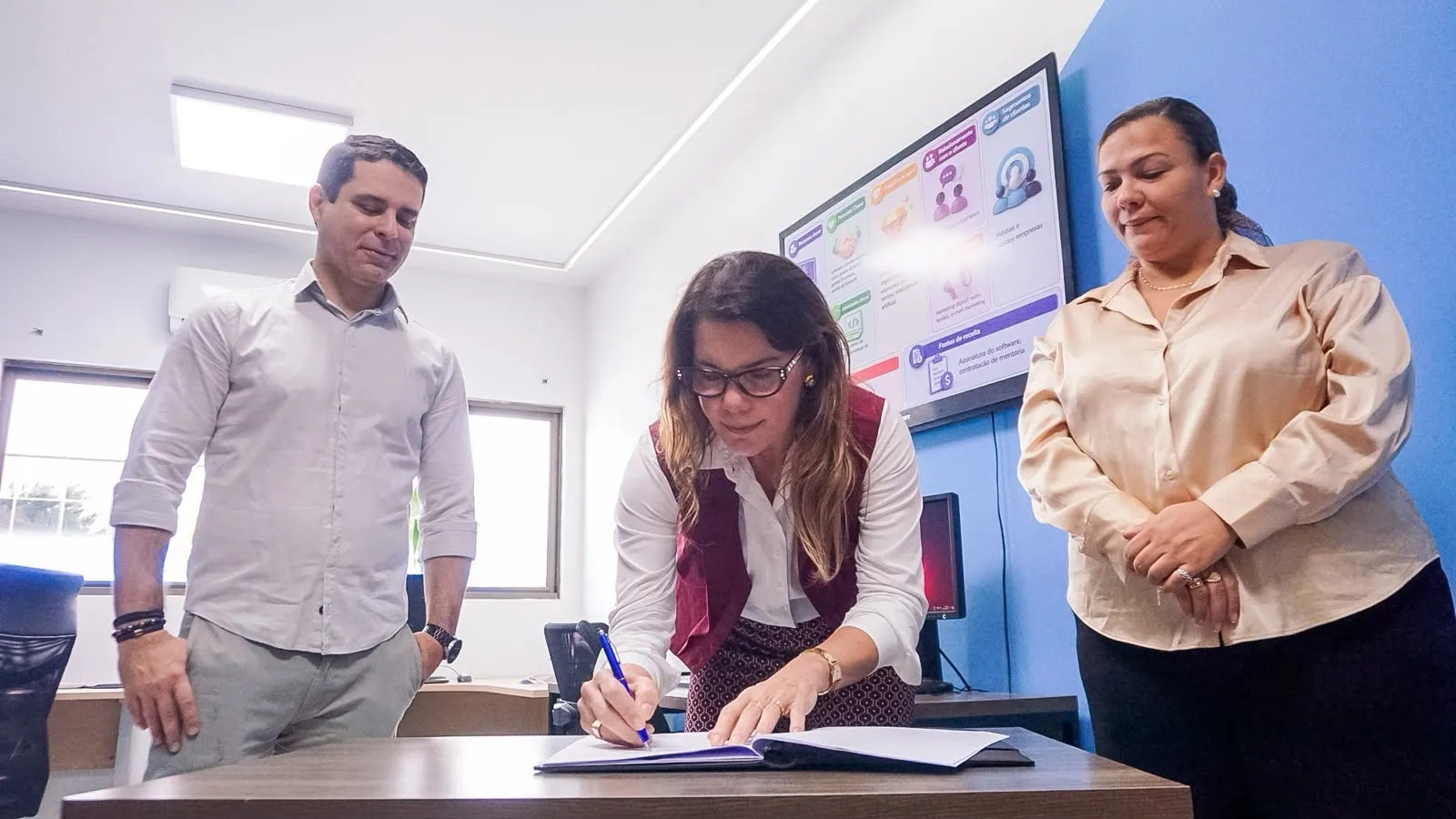 Assinatura do termo de parceria do HubBOX diante de painel de formação em Campina Grande