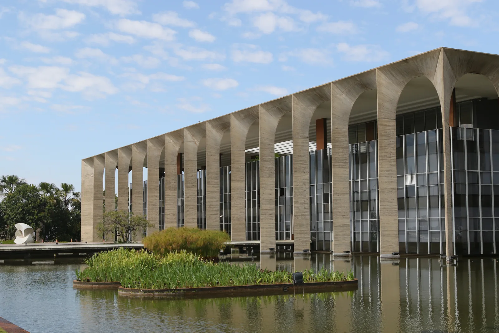 Palácio do Itamaraty, sede do Ministério das Relações Exteriores, com arcos de concreto refletidos no espelho d'água, em Brasília.
