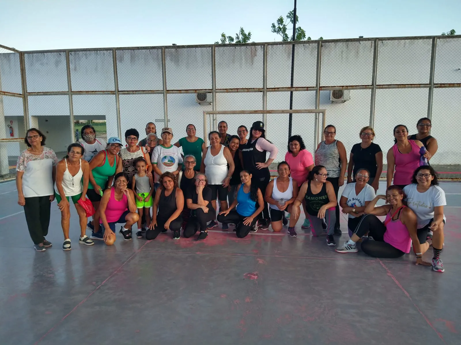 Participantes do programa de atividades físicas reunidos em quadra ao ar livre em Campina Grande