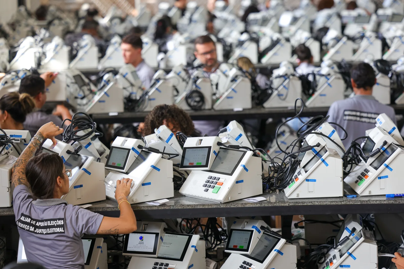 Servidores do Tribunal Regional Eleitoral preparam urnas eletrônicas enfileiradas para o segundo turno, em Brasília.