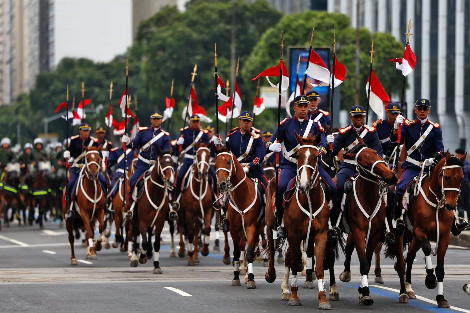 Cavalaria militar desfila com bandeiras do Brasil em avenida, no desfile cívico-militar do 7 de Setembro.