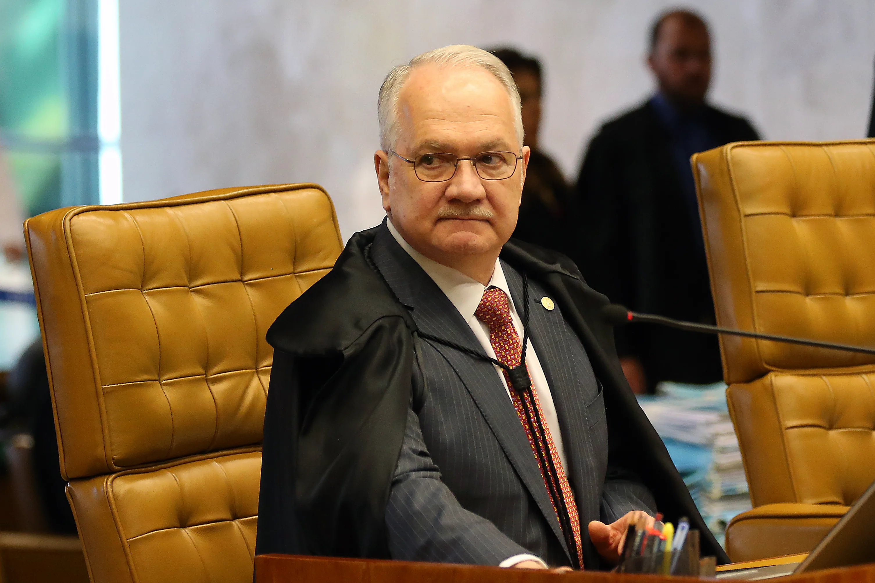 O ministro Edson Fachin, de toga, sentado à bancada do plenário do Supremo Tribunal Federal.