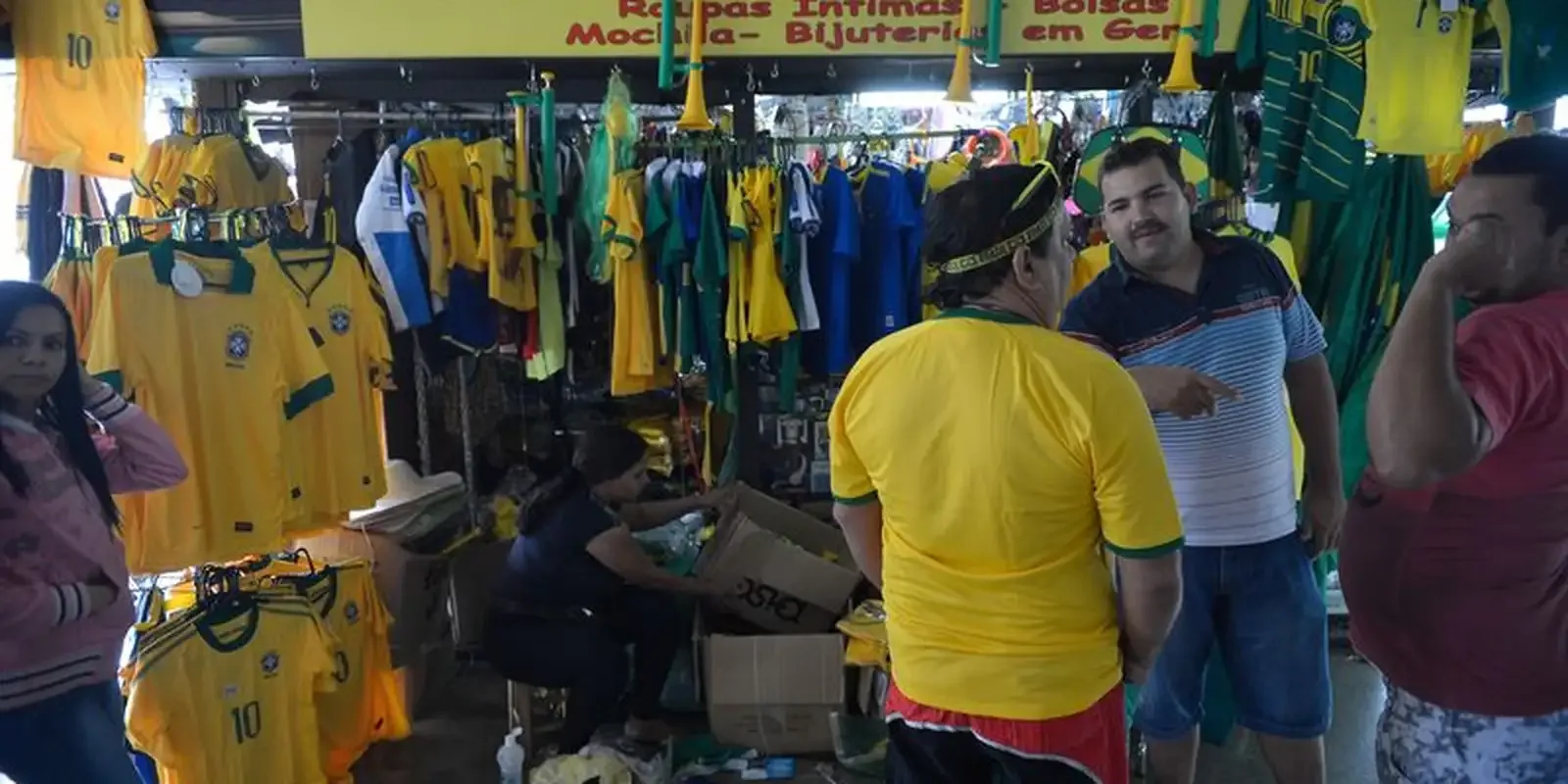 Loja com camisas da seleção brasileira e clientes durante o período da Copa do Mundo.